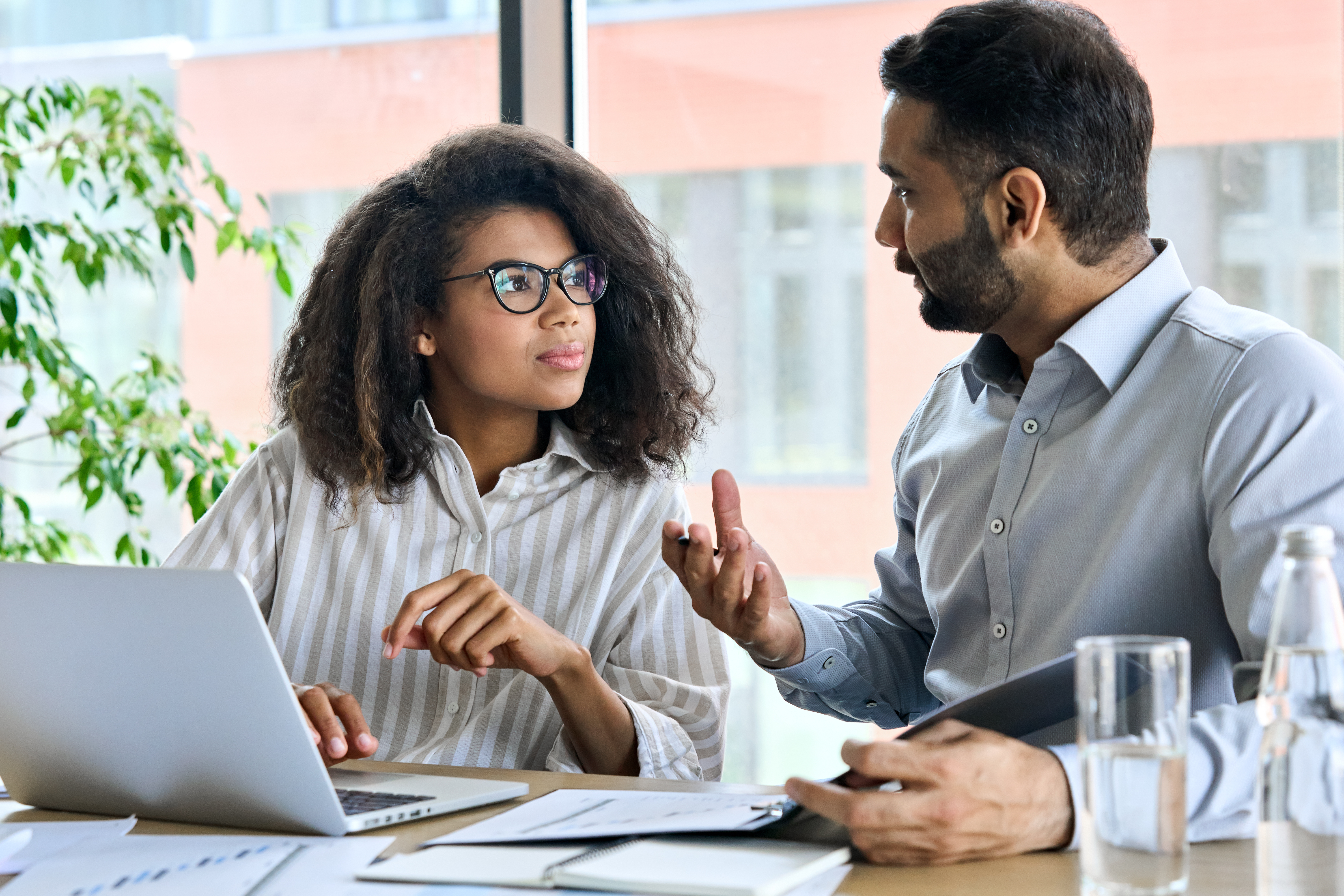 Manager talking with employees, two employees talking