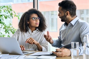 Manager talking with employees, two employees talking
