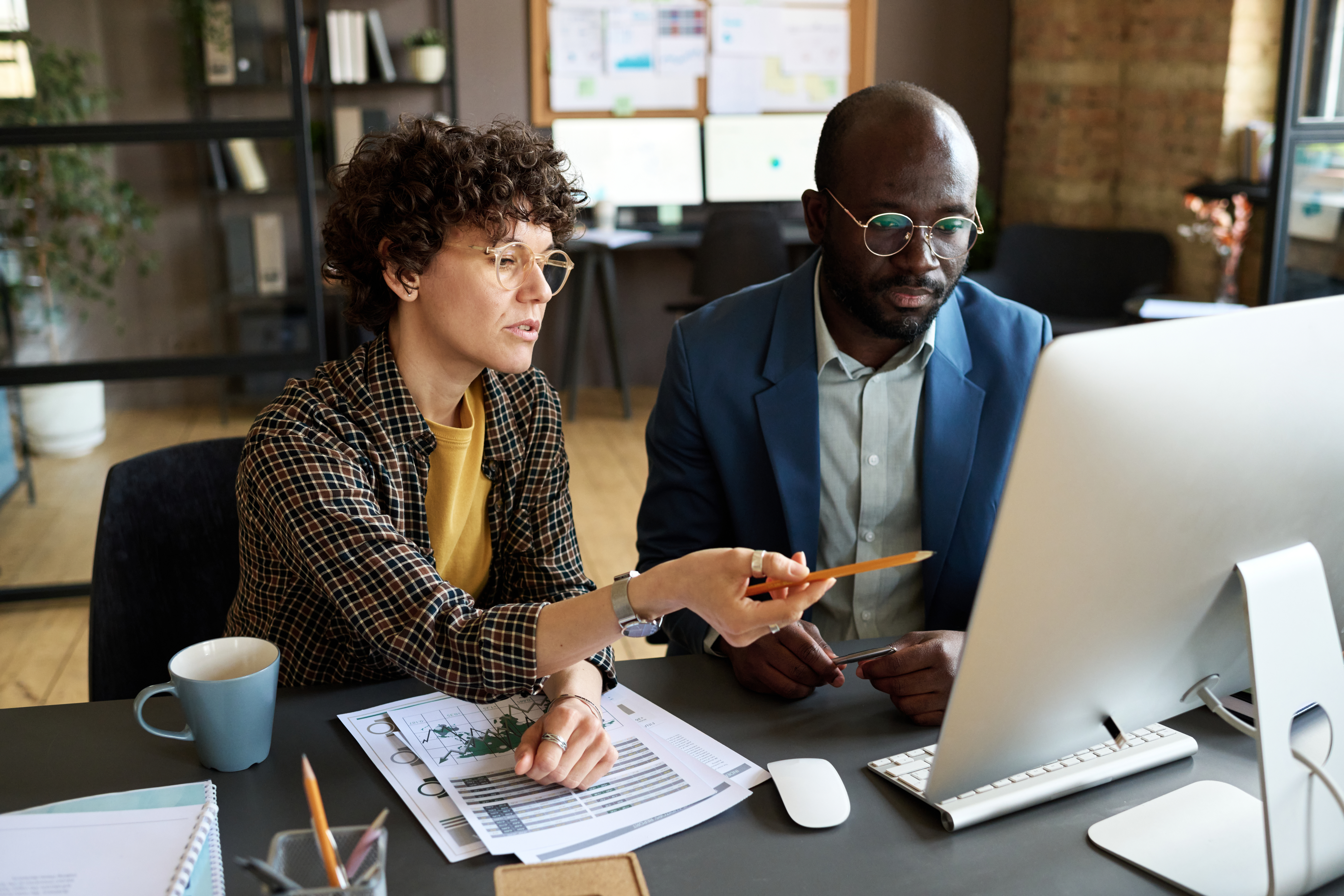 Two employees, man and woman, looking at computer