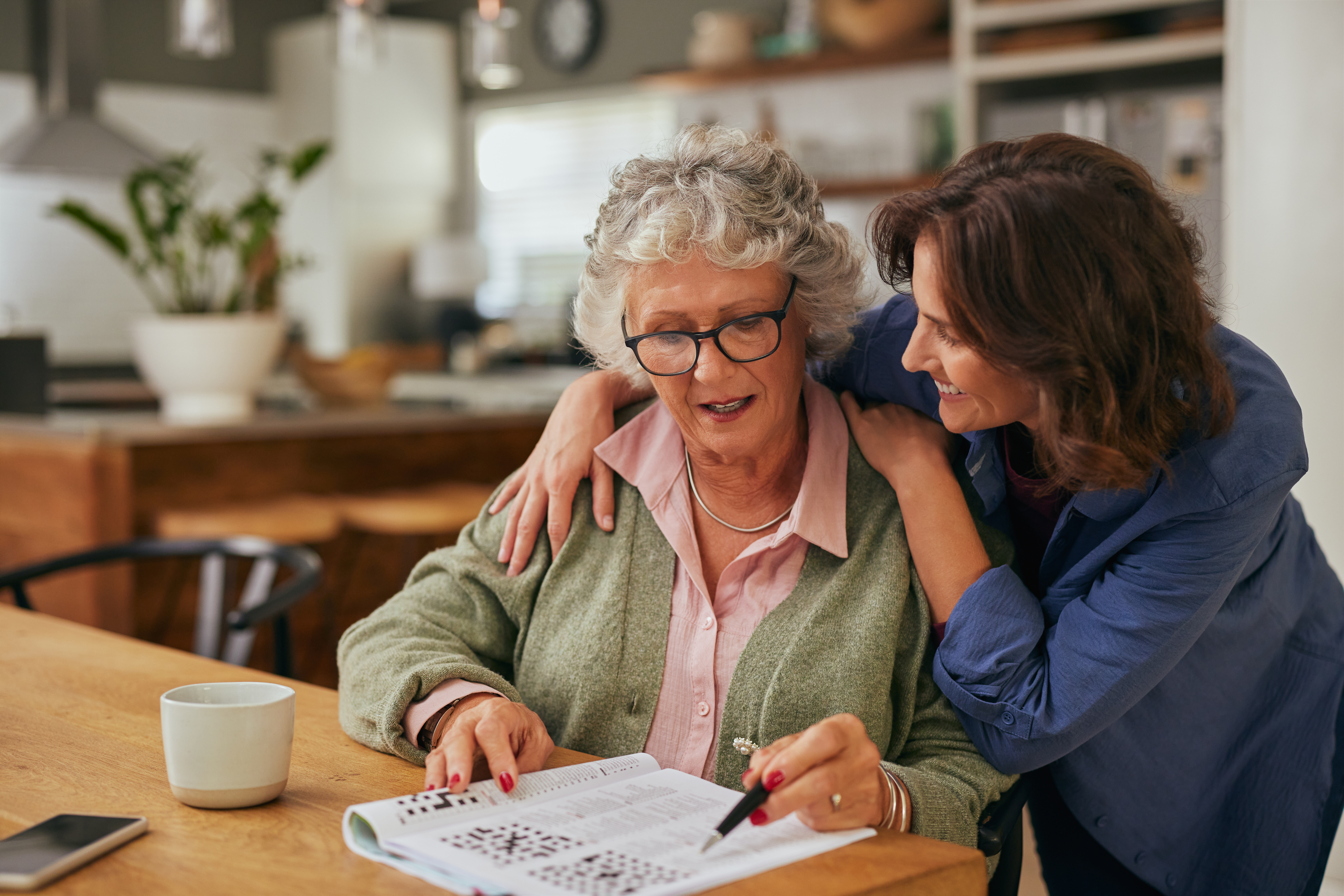 Woman hugging shoulders of mom, smiling