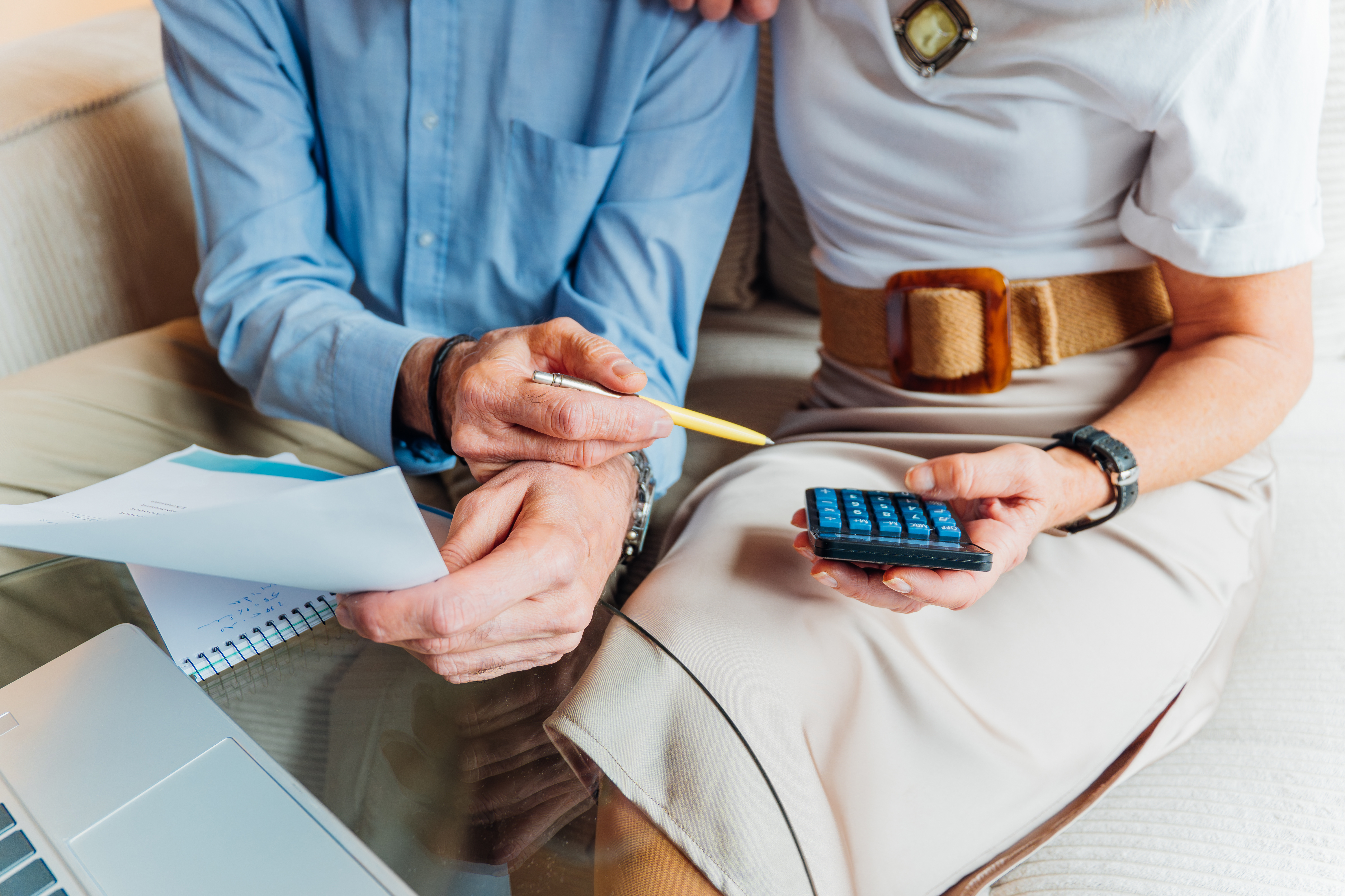 Elderly couple managing household finances and retirement planning, calculating expenses and reviewing bills on a laptop, stressing budget and financial consulting for seniors.