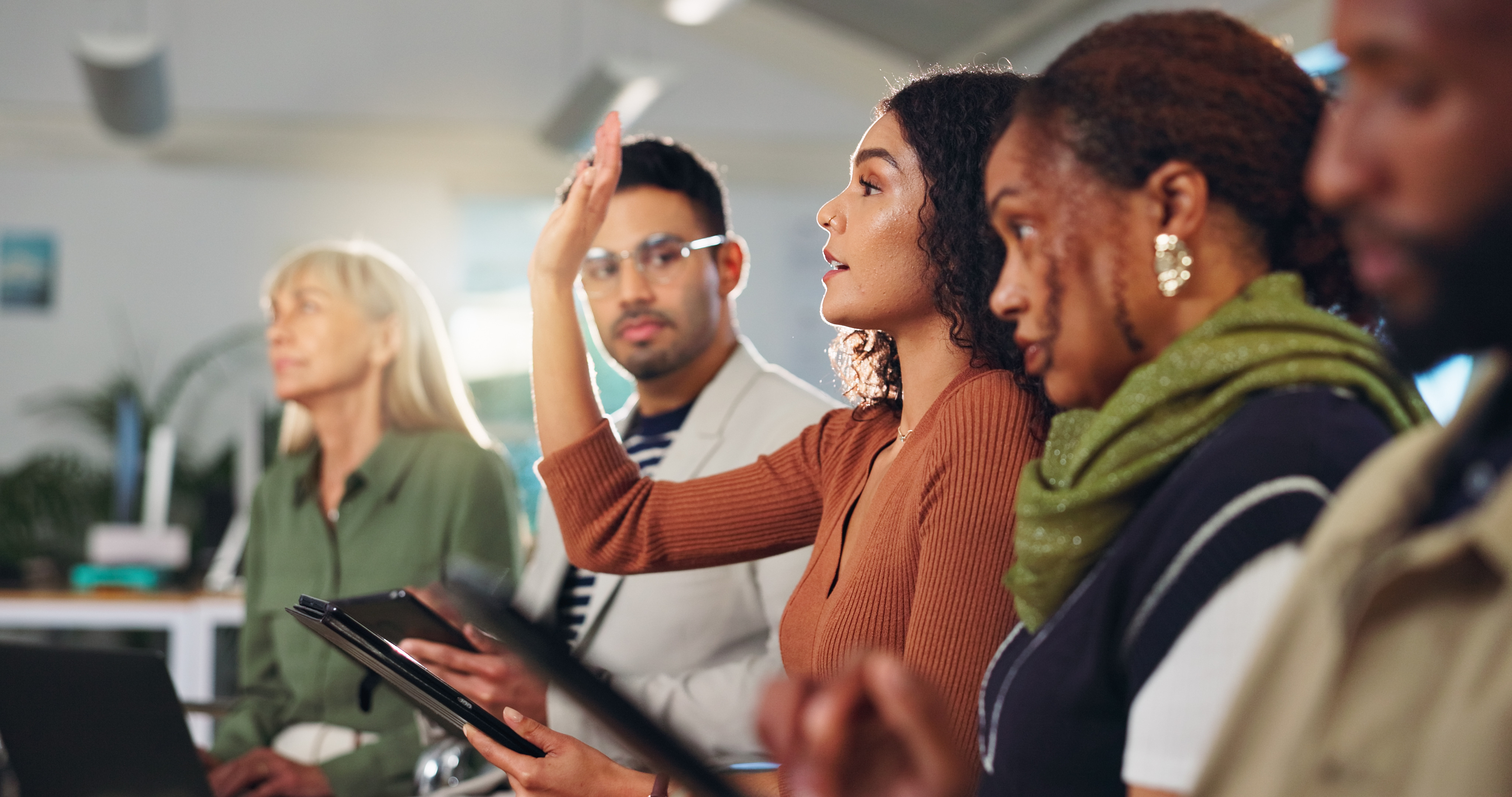 Group of employees, one raising hand