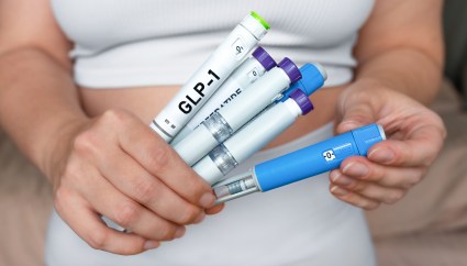 Woman holding multiple GLP-1 injection pens, weight loss and diabetes treatment concept.