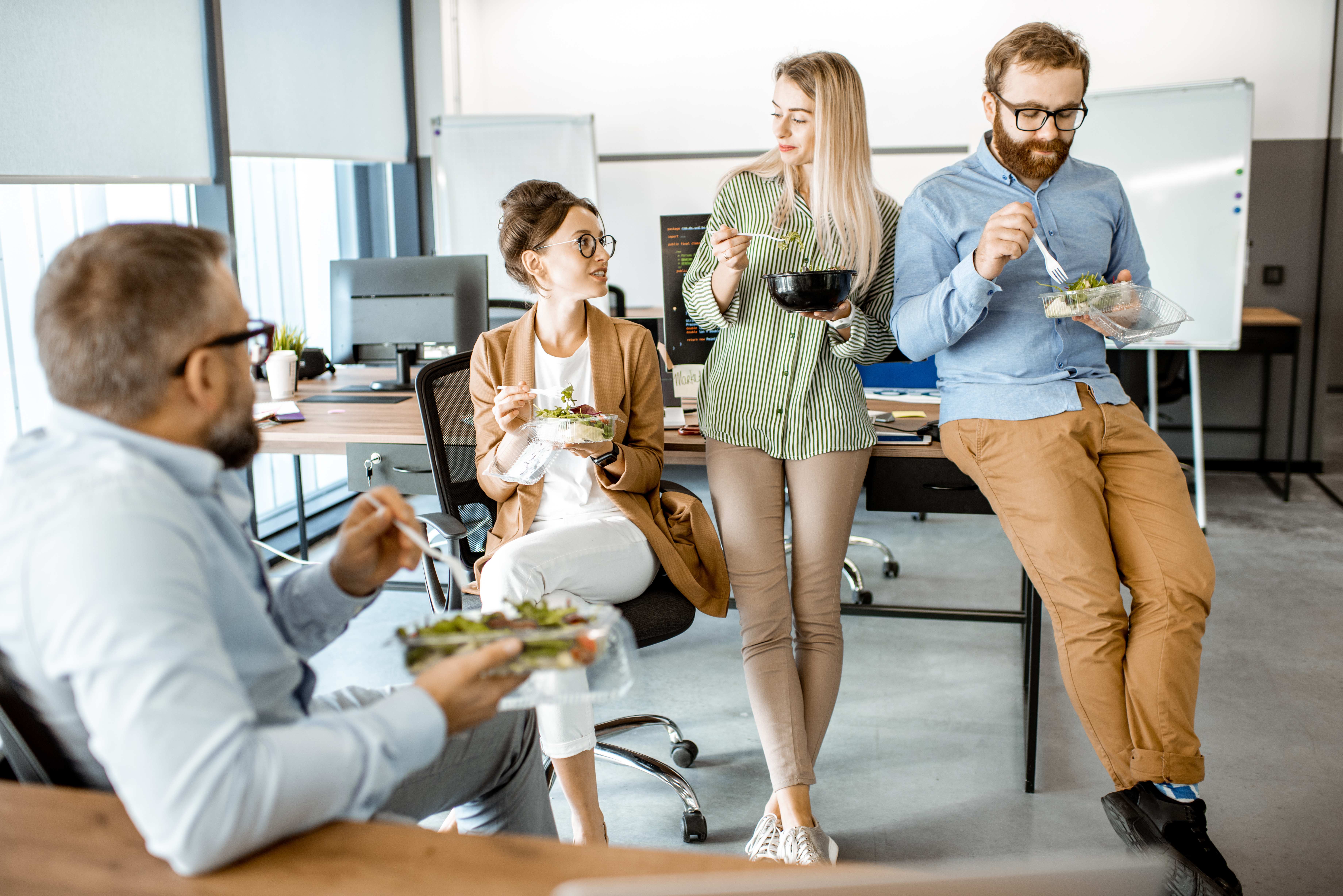 Group of employees eating healthy at work