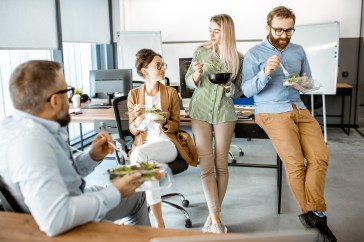 Group of employees eating healthy at work