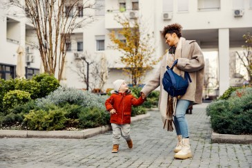 Mom and son walking to daycare, school, smiling