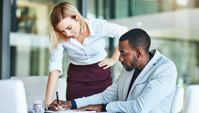 Two employees helping each other