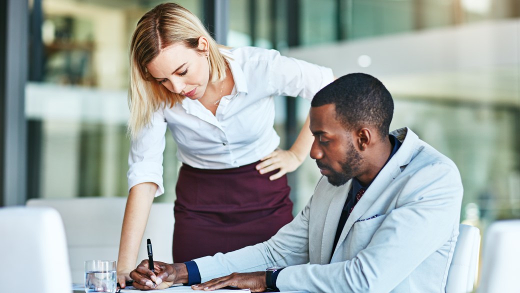 Two employees helping each other