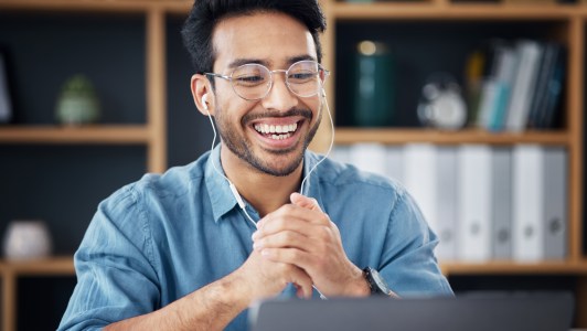 Man on video call, earbuds in, smiling
