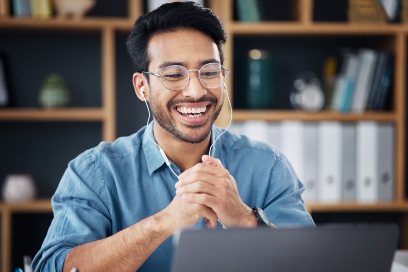 Man on video call, earbuds in, smiling