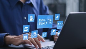 Employee benefits concept. Insurance, paid vacation, office perks, Fringe benefits for employee engagement. Businessman using laptop with employee benefits icon on virtual screen.