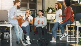 Young coworkers having pleasant talk in office