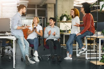Young coworkers having pleasant talk in office