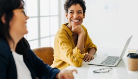Happy business woman talking to her colleague in a meeting